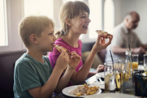 Kids enjoying tasty pizza in restaurant